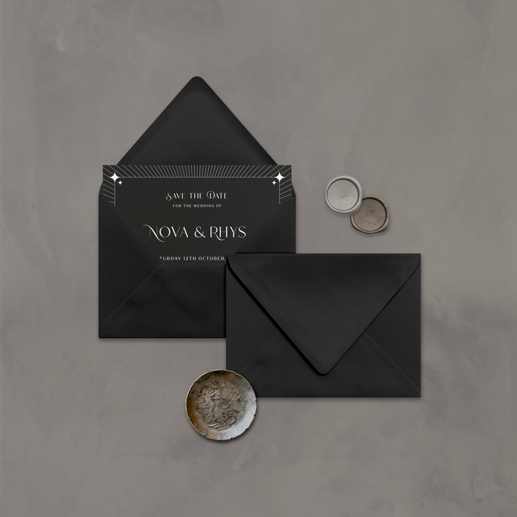 Wedding stationery flatlay with invitation inside a black envelope designed by The Little Paper Shop