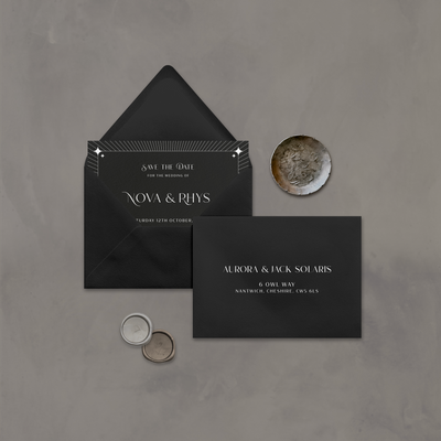 Wedding stationery flatlay with printed address on a black envelope designed by The Little Paper Shop