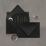 Wedding stationery flatlay with invitation inside a black envelope designed by The Little Paper Shop