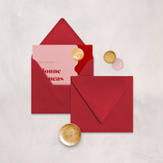 Wedding stationery flatlay with invitation inside a red envelope designed by The Little Paper Shop