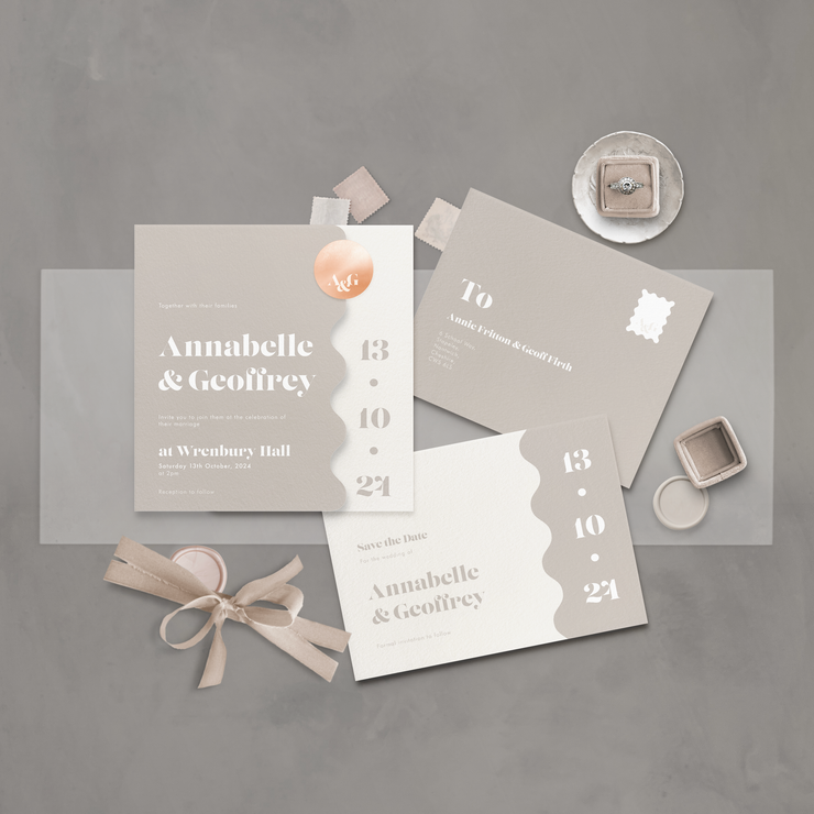 Flatlay of a neutral coloured wavy wedding stationery suite designed by The Little Paper Shop