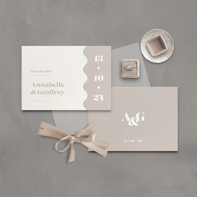 Flatlay of a wavy save the date wedding stationery postcard designed by The Little Paper Shop