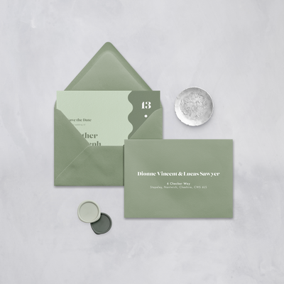 Wedding stationery flatlay with printed address on green envelope designed by The Little Paper Shop