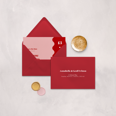 Wedding stationery flatlay with printed address on a red envelope designed by The Little Paper Shop