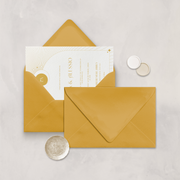 Wedding stationery flatlay with invitation inside a mustard envelope designed by The Little Paper Shop