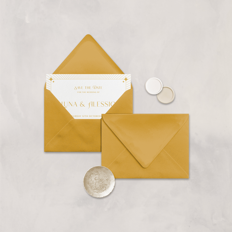 Wedding stationery flatlay with invitation inside a mustard envelope designed by The Little Paper Shop