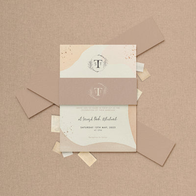 Wedding stationery inviation wrapped with a belly band featuring personalised monogram  designed by The Little Paper Shop